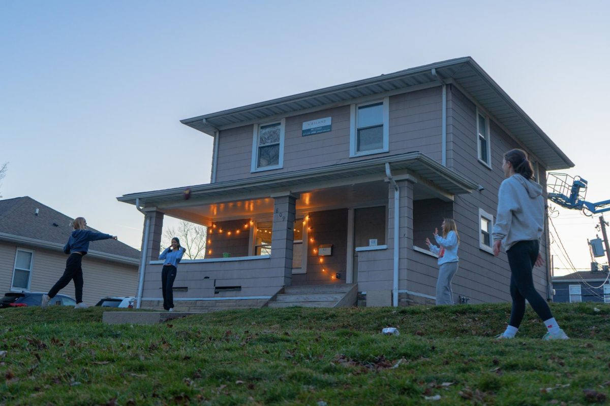 A group of girls plays football in front of a house near East Daniels Road and South Hale Street by Roland Realty on Feb. 29.