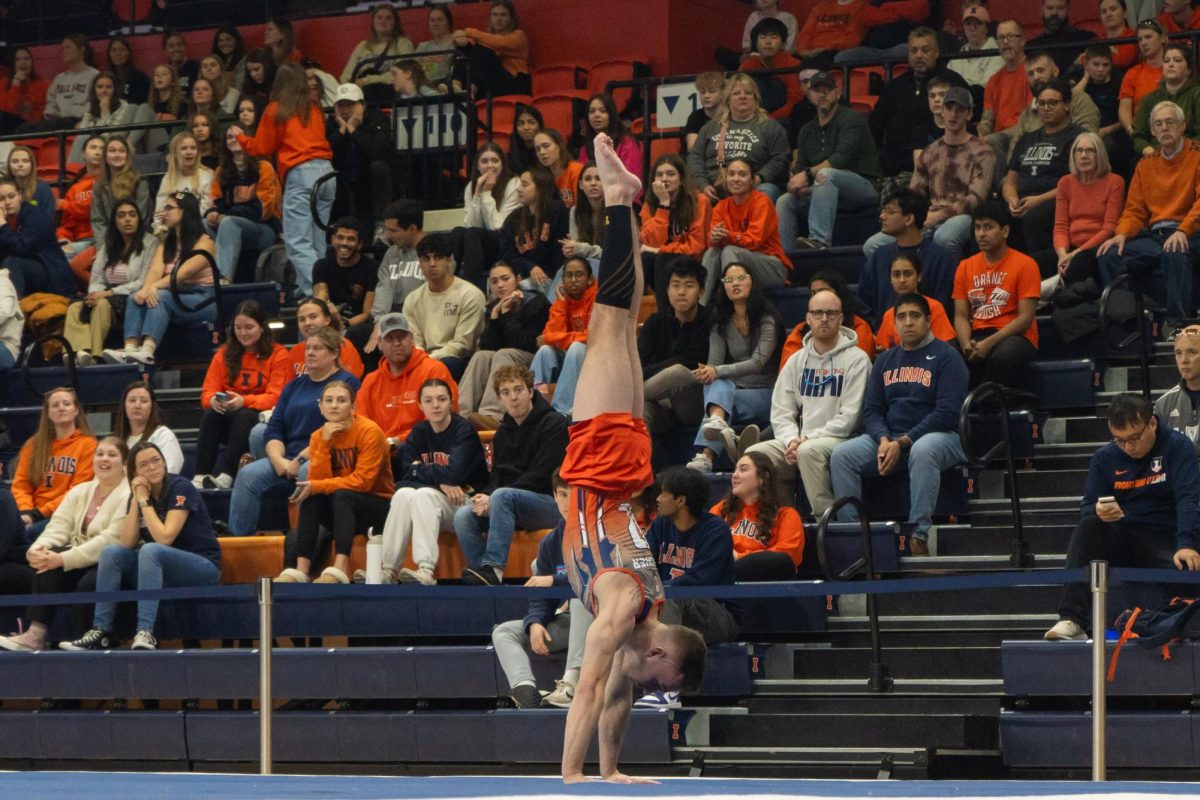 Graduate student Michael Fletcher holds a handstand during his floor routine during the meet with Michigan on Feb. 3. 