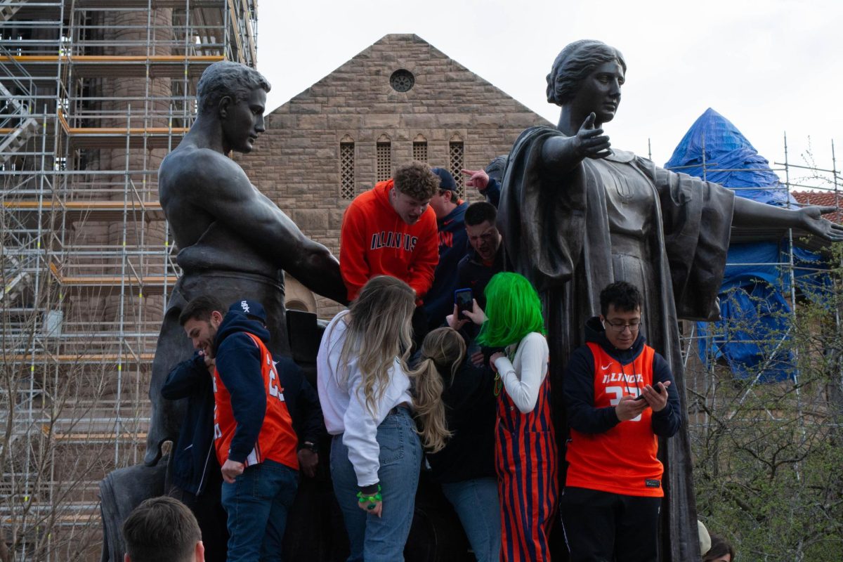 Students take pictures with the Alma Mater after Illinois wins the Big 10 Championship Tournament on Mar. 17. 