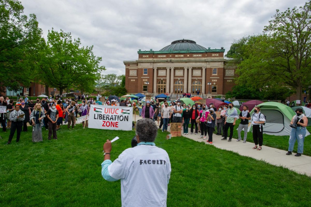 University faculty member speaks in front of protestors on the south side of the Main Quad.