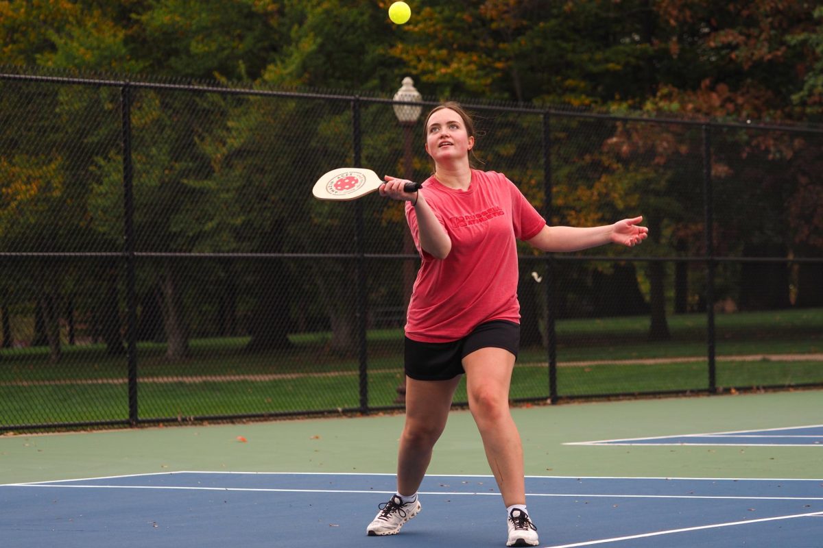 Junior Emily Schutt reaches to return a ball our of the air at pickleball practice on Oct. 14. Schutt was extremely open to learning the rules and tactics of the game.
