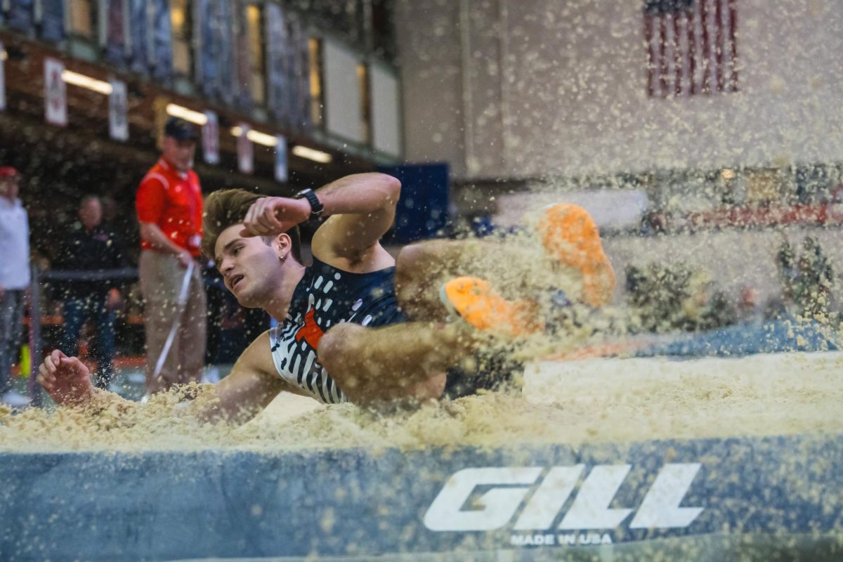 Senior Aiden Ouimet lands in the sand after his long jump on Jan. 26.