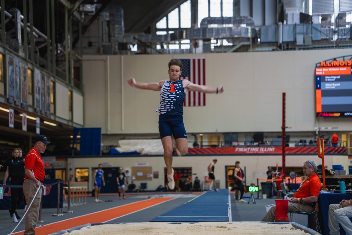 Senior Aiden Ouimet mid-air during his long jump on Dec. 1.
