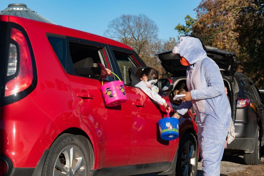 Children attending a drive-thru trick-or-treating event at the Champaign County Fairgrounds receive candy on Saturday. Many Champaign-Urbana residents celebrated Halloween with COVID-19 precautions this year.