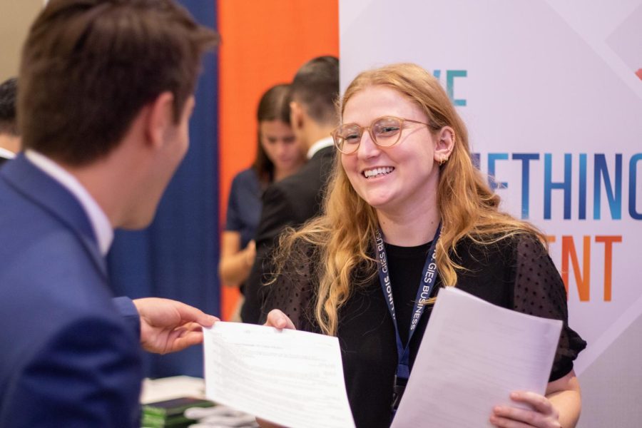 A recruiter speaks with a student during the Gies Business career fair at the I-Hotel and Conference Center on Thursday. Students reflect on both, the Engineering and Gies Business, career fairs with it being held in-person and online. 