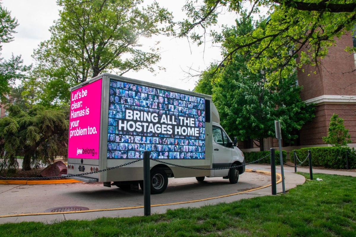 A truck sits between Gregory and Lincoln Halls with illuminated screens on the sides and back.