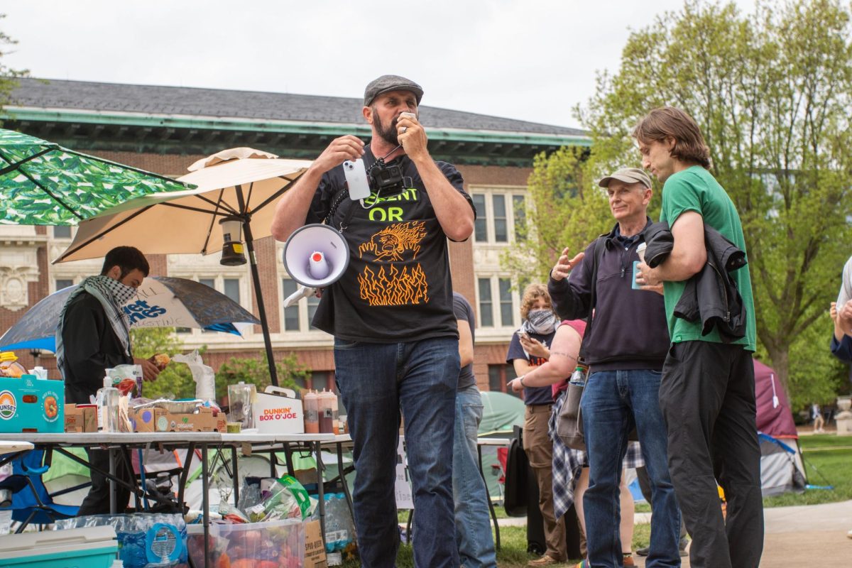 A speaker calls demonstrators liars with a megaphone at the encampment on Friday.