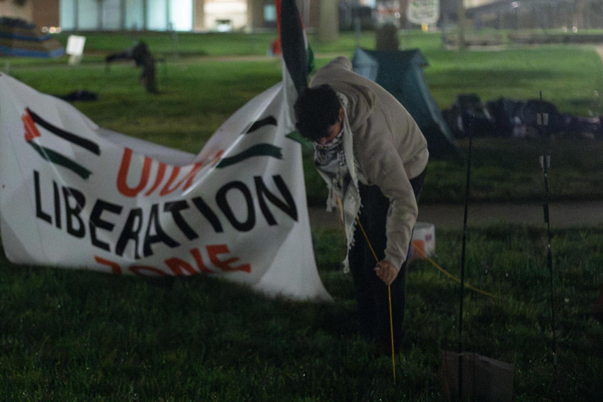 A protester unties the sign in front of Foellinger Auditorium Friday morning.