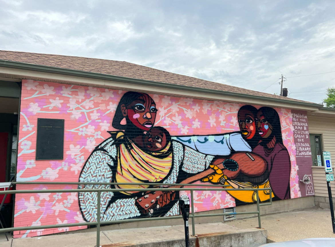 A mural depicting people sharing a guitar on the Cunningham Township building in Urbana, painted by Langston Allston, an artist with ties to the area, in 2022. Allstons work has been featured on the Champaign County African American Heritage Trail website.