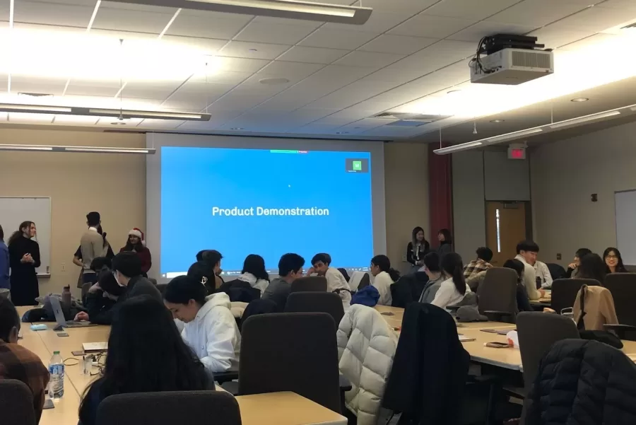 Eesha Barua, sophomore in Engineering, pictured in a Santa hat, prepares a product demonstration from 7000 Languages at the Fall 2022 Hack4Impact UIUC Product Showcase.